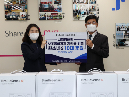 다올금융그룹 최석종(오른쪽) 부회장이 실로암시각장애인복지관 김미경(왼쪽) 관장에게 최신 점자정보단말기 10대를 전달하고 있다.  다올금융그룹 제공